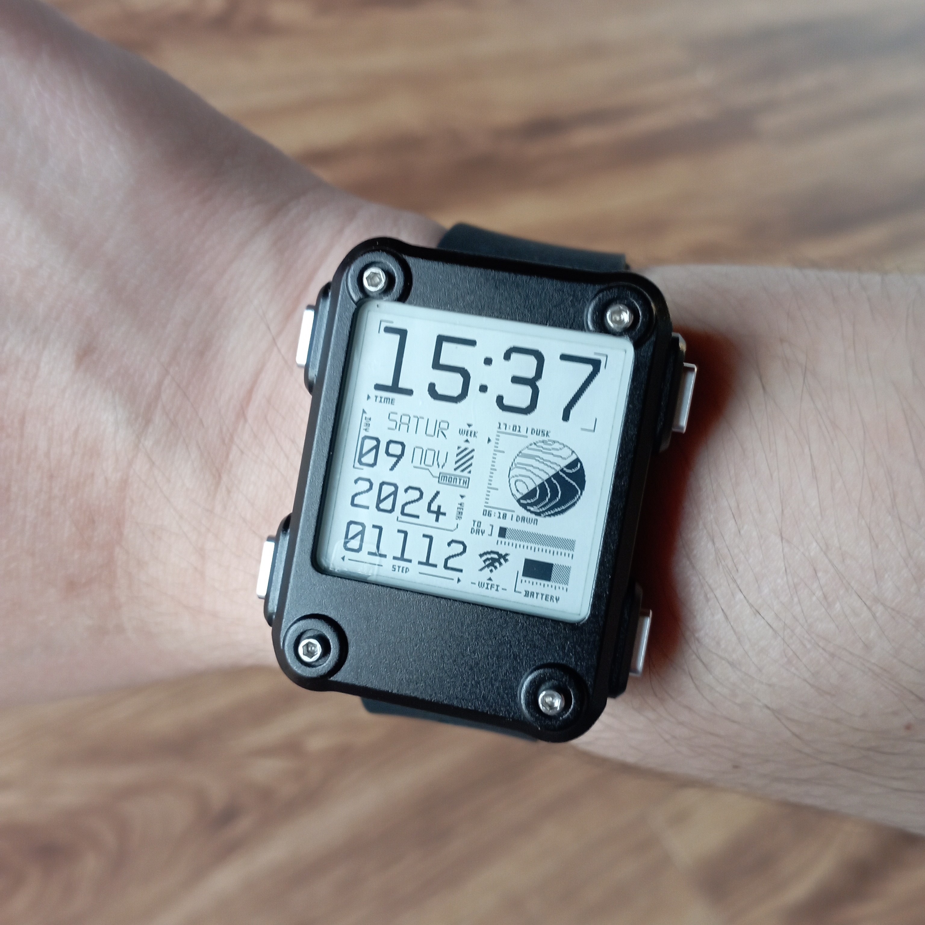 Watchy with a black aluminium case being worn on a wrist